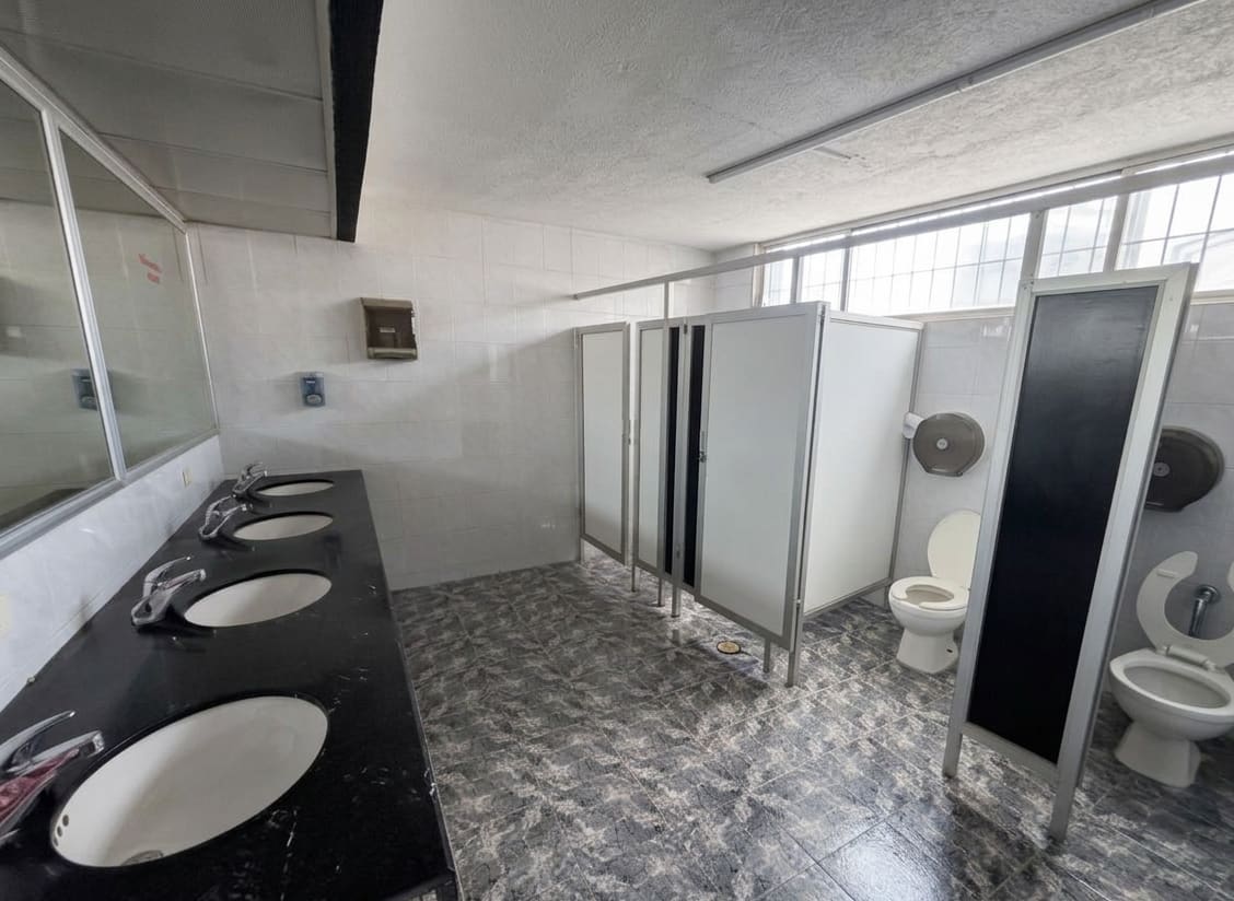 Baños del edificio con cubículos y lavabos dobles